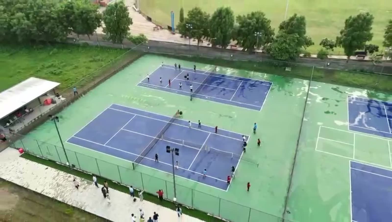 Tennis coaching session in progress at Drona Sports Academy